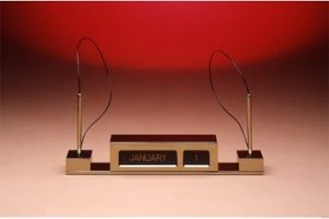 Elegant perpetual calendar on display with red background.